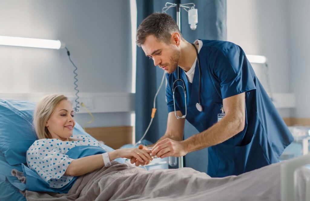 the medical worker performs the procedure on the patient lying on the bed