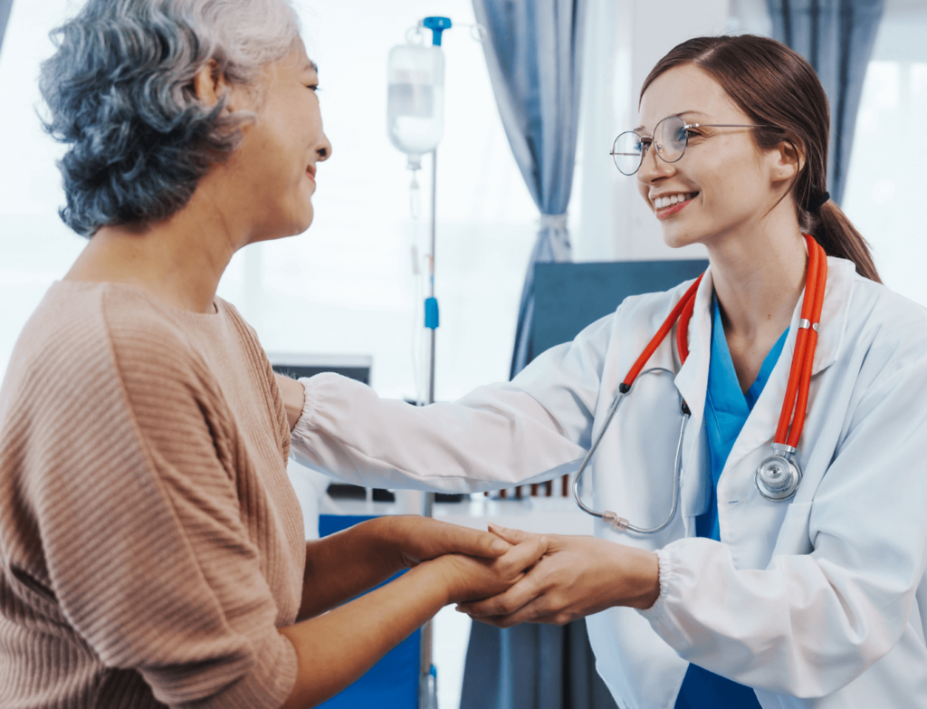 a medical worker holds the hand of an elderly patient. both are smiling