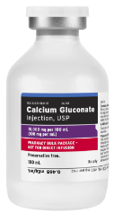  A white medical vial with a silver cap and a label that reads "Calcium Gluconate Injection, USP." The label also shows "10,000 mg per 100 mL (100 mg per mL)" and "PHARMACY BULK PACKAGE - NOT FOR DIRECT INFUSION" in red text, along with other smaller text details.