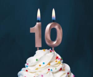 a photo of frosting with sprinkles topped with lit number 10 candles
